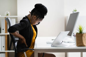 Woman with back pain at sitting desk